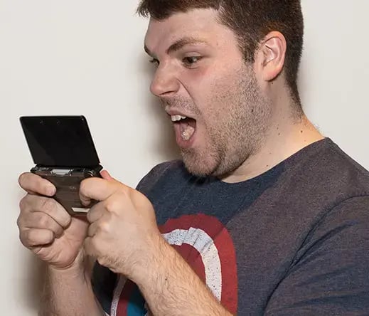 Photo of Alexandre enthusiastically playing a video game
