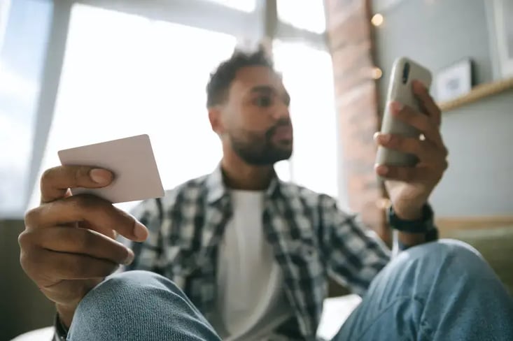 Un homme réalise un achat sur un site web depuis son téléphone